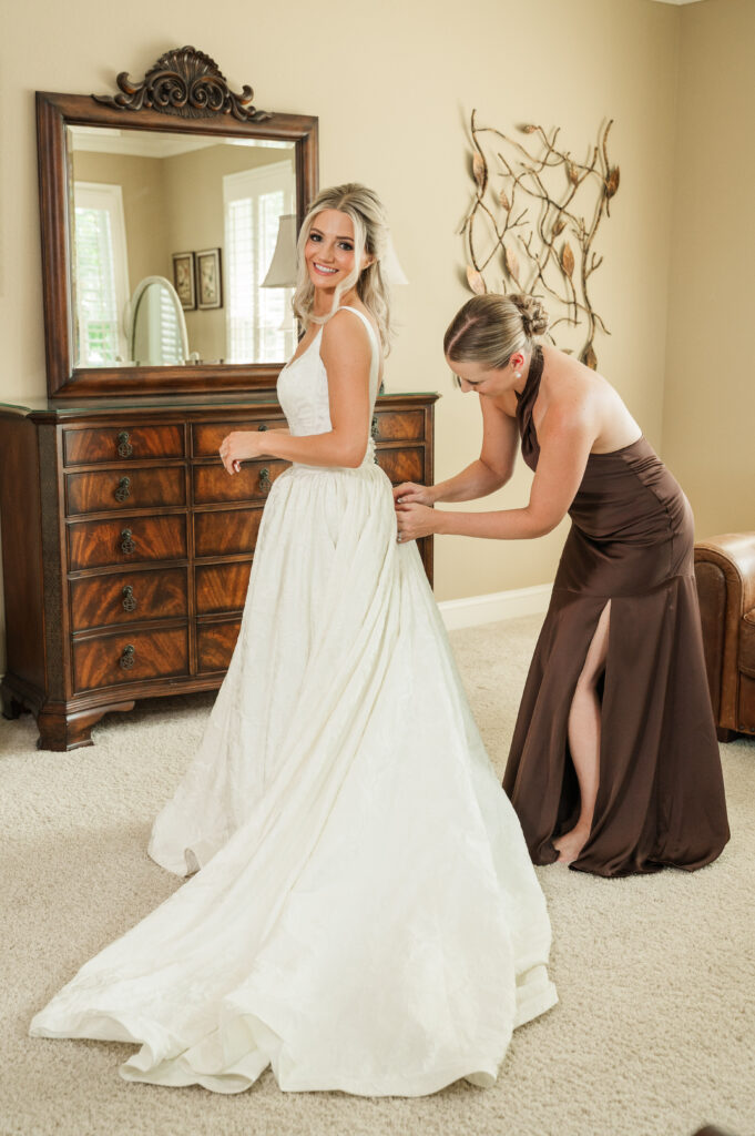 Chelsey buttoning Jordan's wedding gown