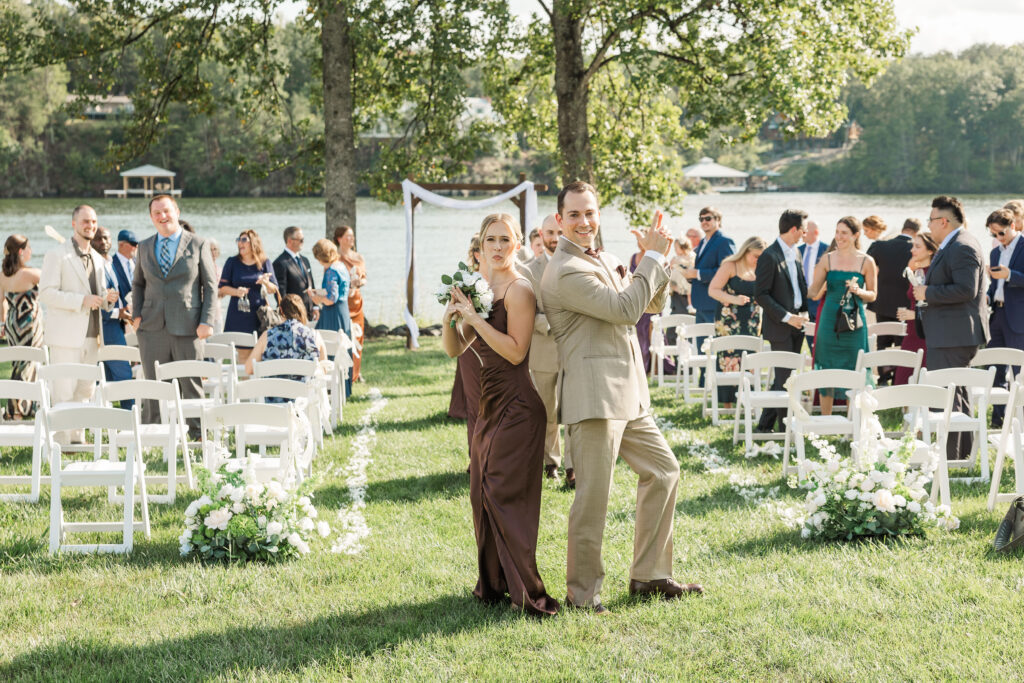 bridesmaid and groomsman being silly as they walk down the aisle