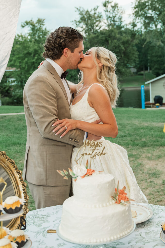 couple kissing after cutting the cake