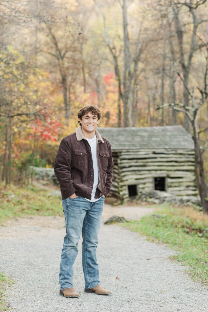 Western Albemarle Senior standing in front of log cabin at Humpback Rocks
