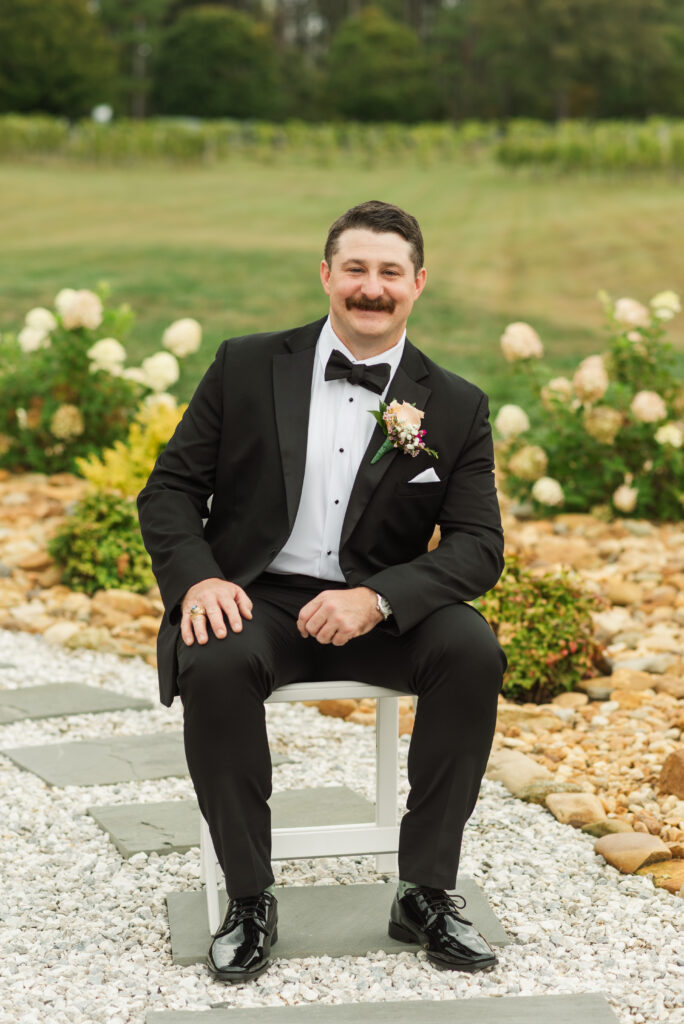 groom sitting in garden at Harware Hills Vineyard